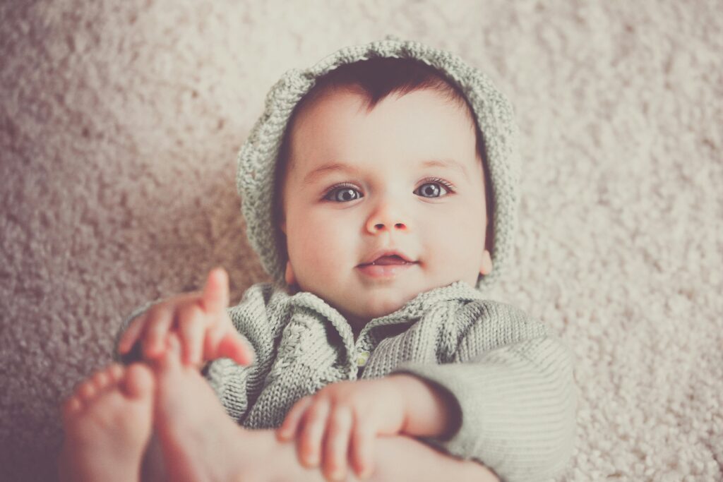 cute baby holding legs during its first year